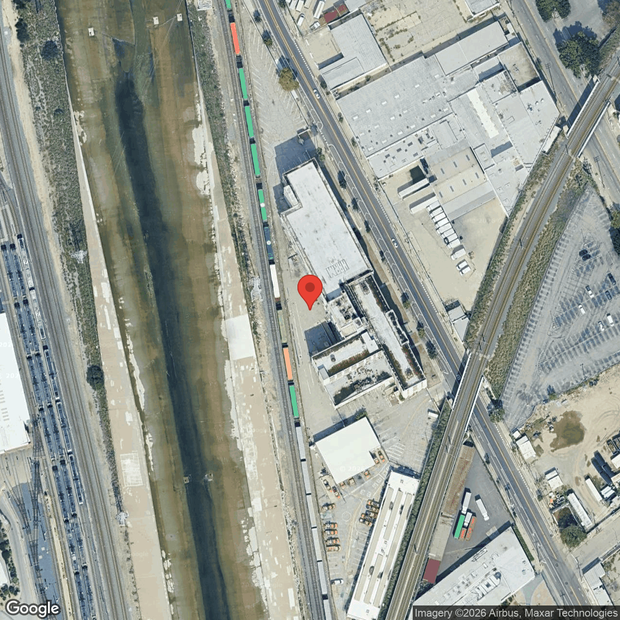 Aerial of HCM-587 Lincoln Heights Jail parcel showing the building, adjacent rail right-of-way, and proximity to the LA River concrete channel.