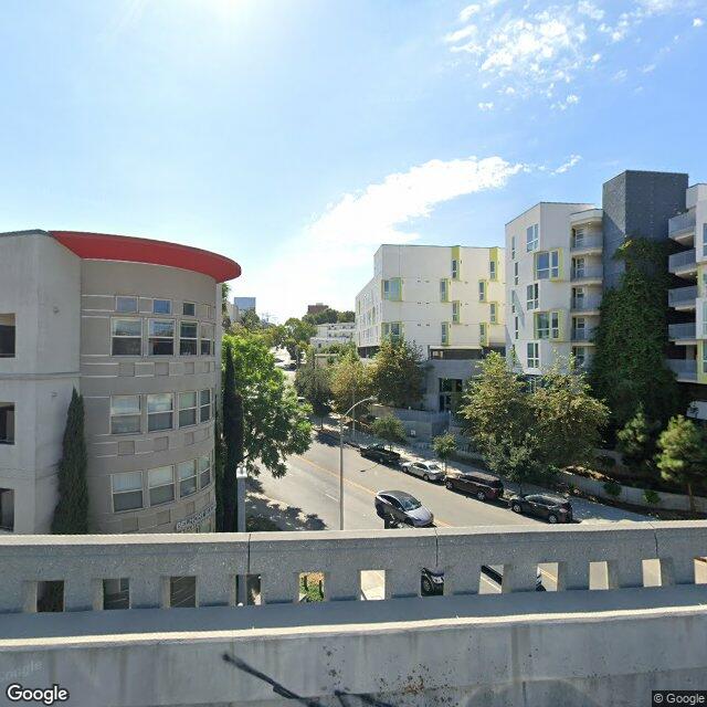 Street view of the Belmont Station Apartments wrapping the historic portal site. The historic Toluca Substation dome is not visible from public streets — it sits within the apartment courtyard.