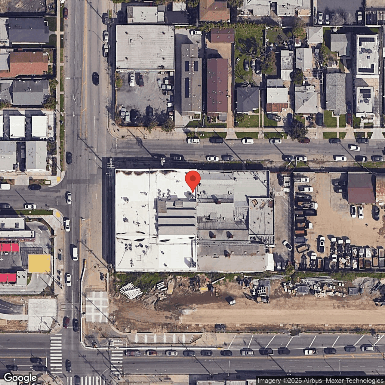Aerial view of the Cadet Records parcel at the corner of S Normandie Ave and W 58th St, showing the L-shaped building footprint, vacant lot to the south, residential block to the north, and adjacent commercial uses.